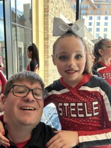 Dave Engel with his daughter Gabby at a youth athletic event, representing family involvement and support in youth sports travel fundraising